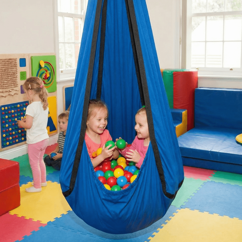 Sensory hammock swing pod for autism and ADHD, child sitting inside with play balls