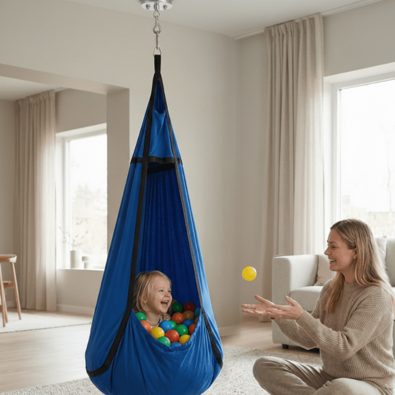 Sensory hammock swing pod for autism and ADHD, child sitting inside with play balls
