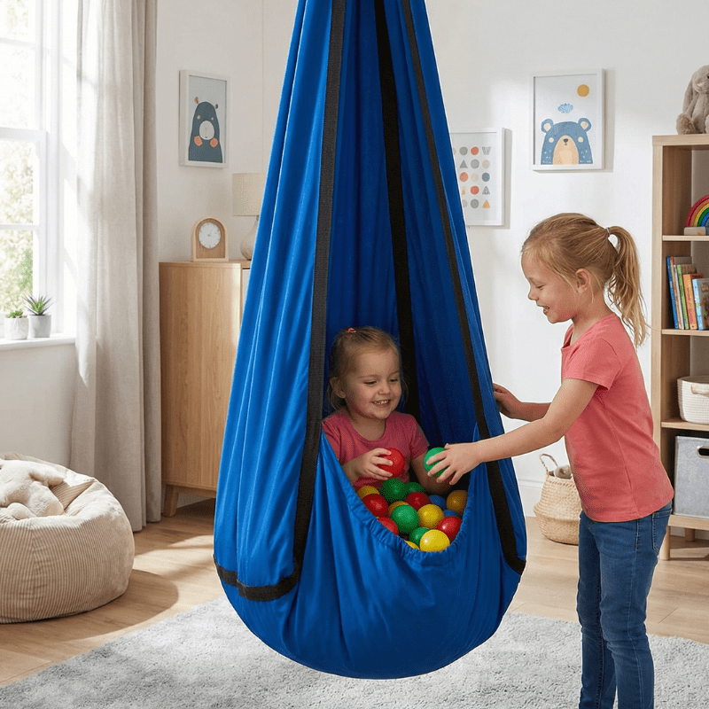 Sensory hammock swing pod for autism and ADHD, child sitting inside with play balls